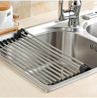 Compact steel folding draining rack on the sink for dishes, kitchen utensils, cutlery, vegetables, fruits